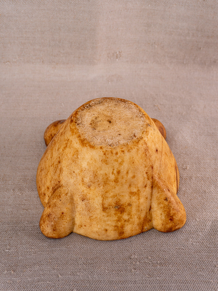 Whimsical animal-shaped baked item, reminiscent of Provencal French silhouettes, on beige fabric.