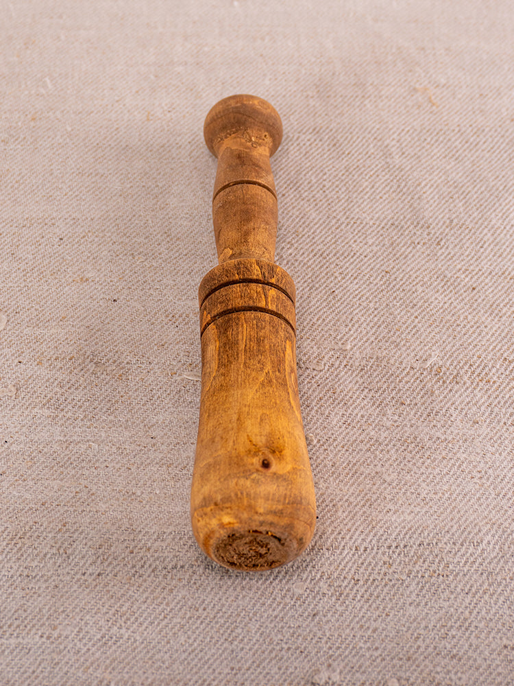 Antique French marble mortar and pestle with rounded handle, Provencal silhouette on beige textured fabric background.