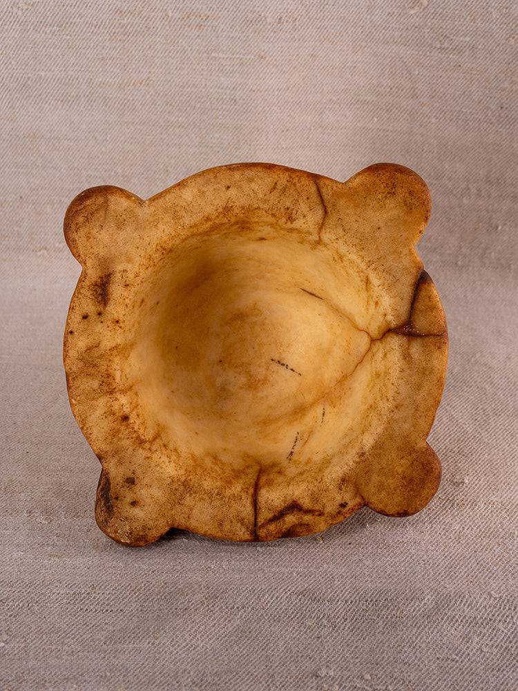 Antique French marble mortar and pestle with rounded 18th-century Provencal form, shown on rustic coarse fabric.