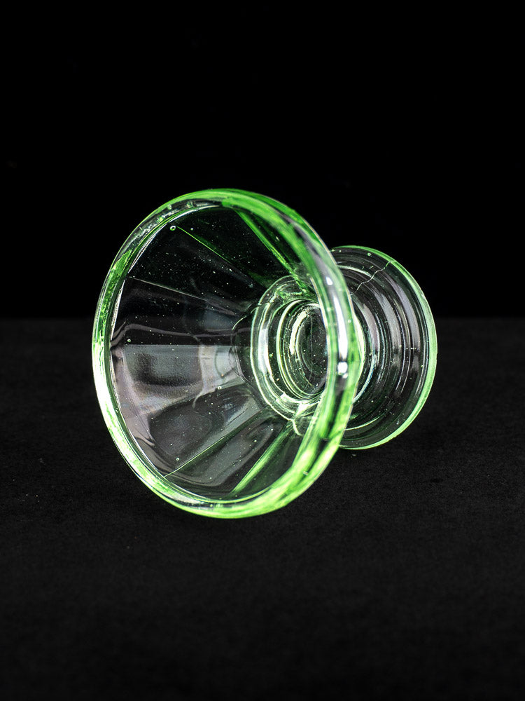 Set of 12 French Art Deco uranium glass sherbet coupes glowing green on black background.