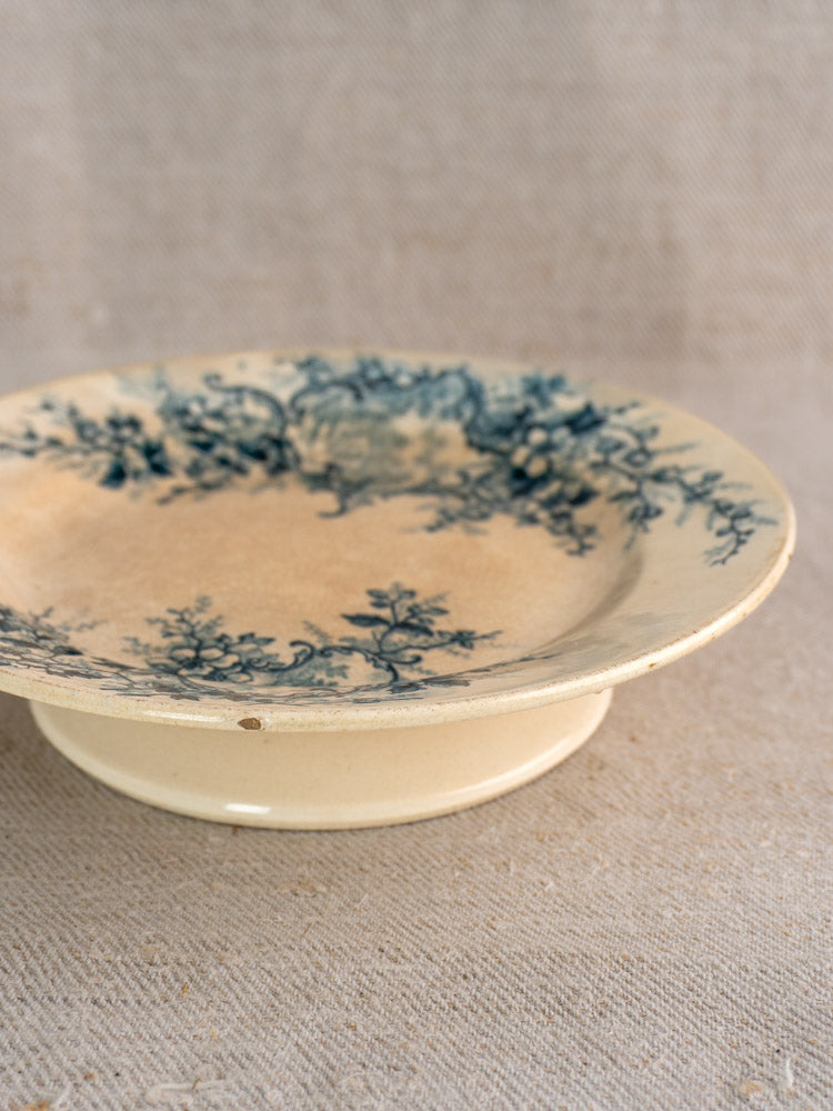 Antique French Boulenger Choisy-le-Roi Pompadour compote plate with blue floral design on cream ceramic, aged patina shown.