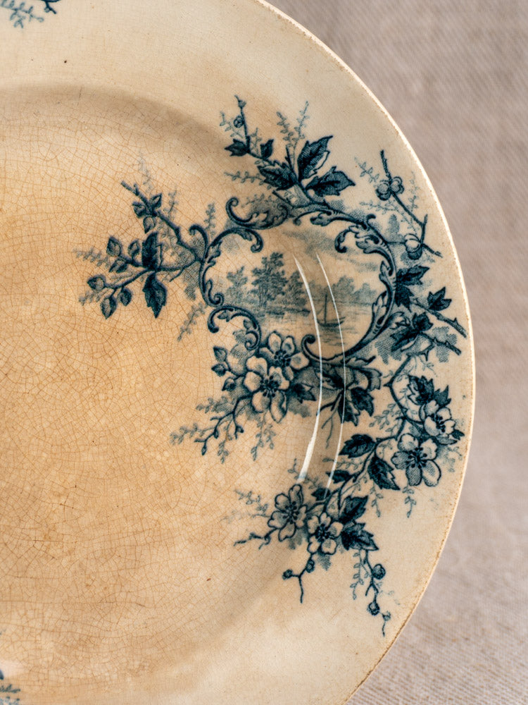 Antique French Boulenger Choisy-le-Roi compote plate with blue floral design, swirled rim, and visible vintage wear.