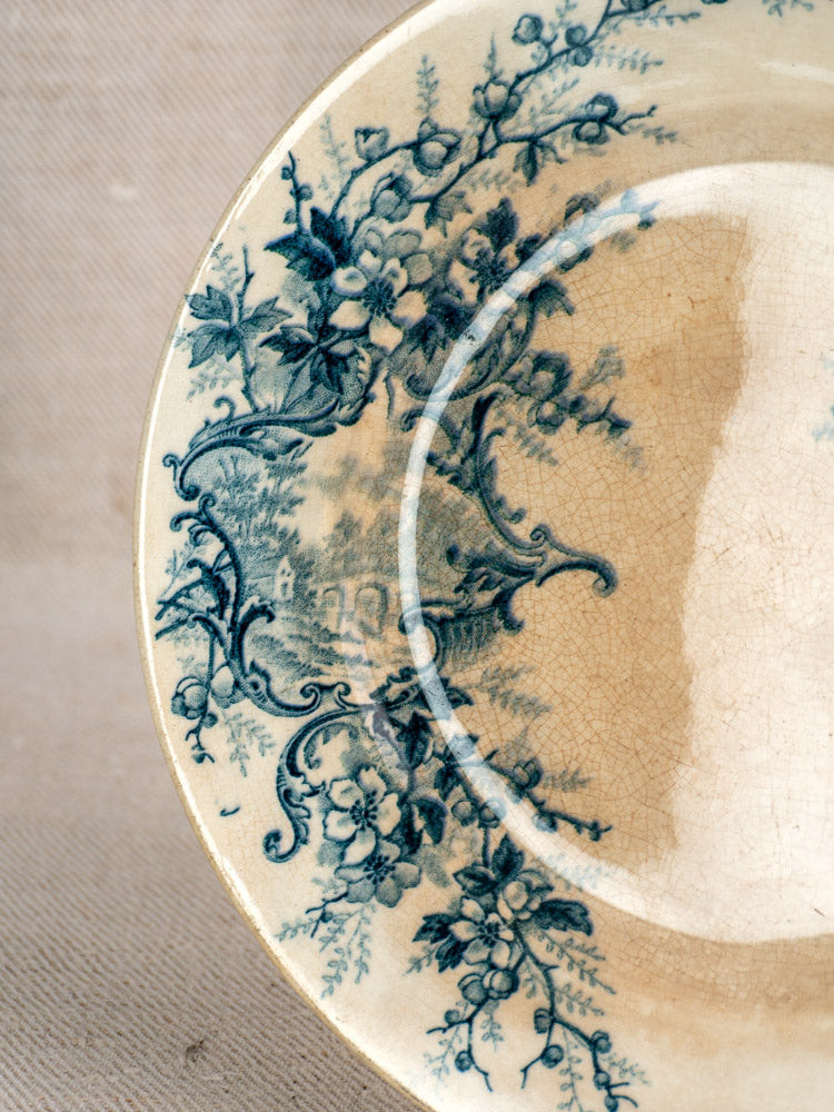 Antique French Boulenger Choisy-le-Roi compote plate, Pompadour pattern, blue floral on cream with visible aging on fabric.