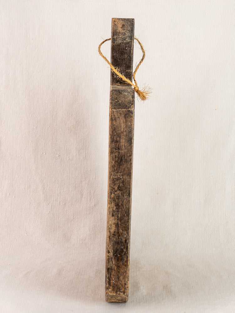 Antique French hand-carved cutting board with diamond handle and twine loop, circa 1850, against plain background.