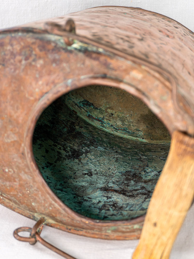 French hammered copper water carrier, 19th-century, with wide opening, greenish interior corrosion, wooden handle.