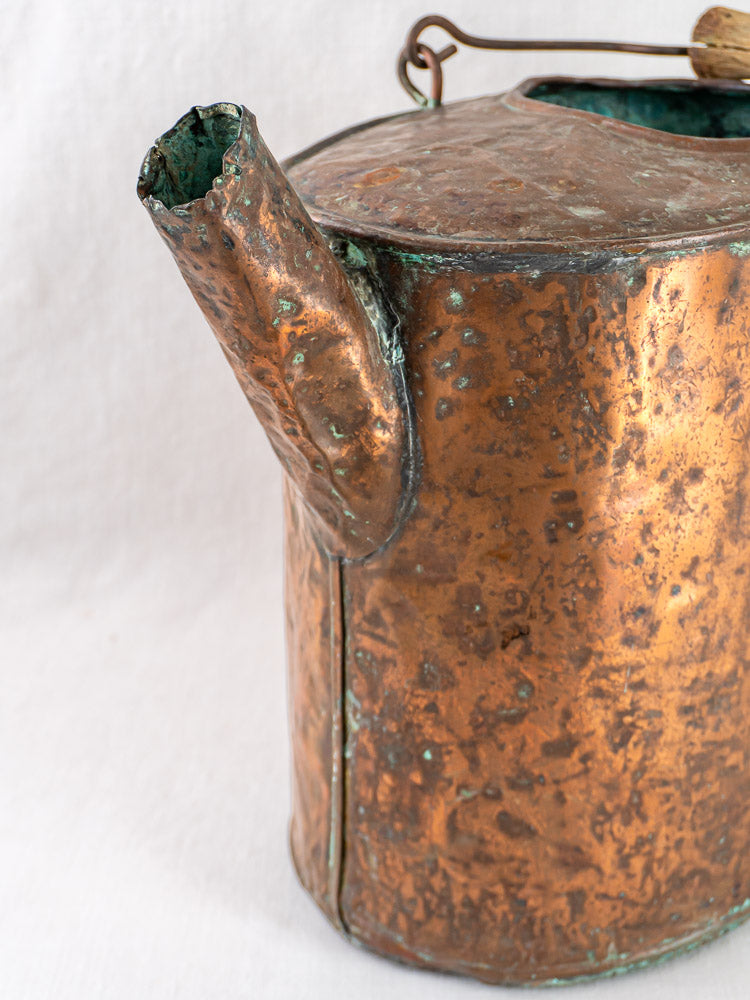 French 19th-century hammered copper water carrier with dented spout and textured patina on white background.