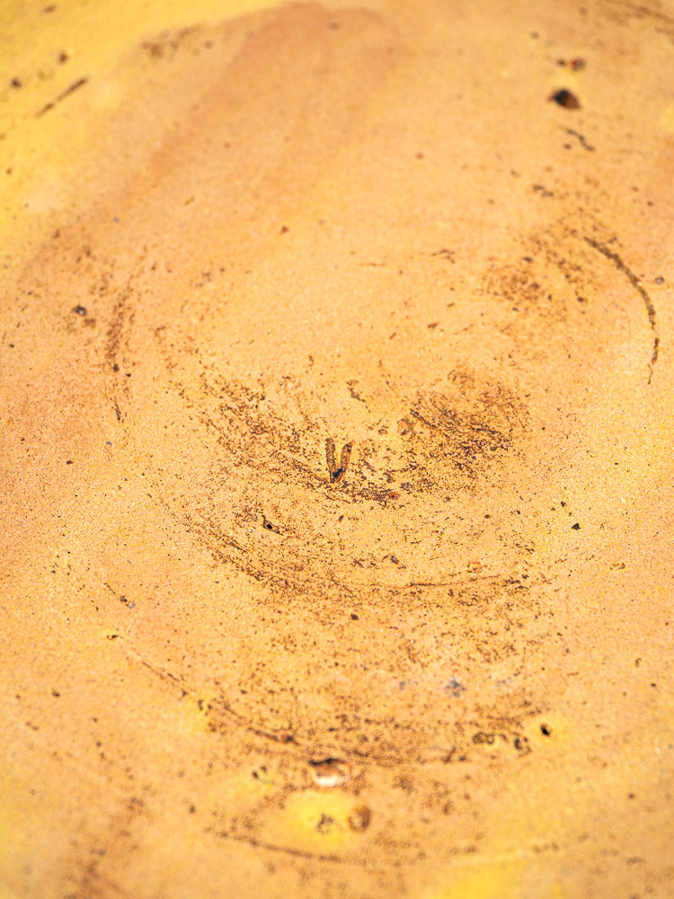 Antique French slipware bowl with textured yellowish-brown glaze, circular motifs, and a weathered finish.