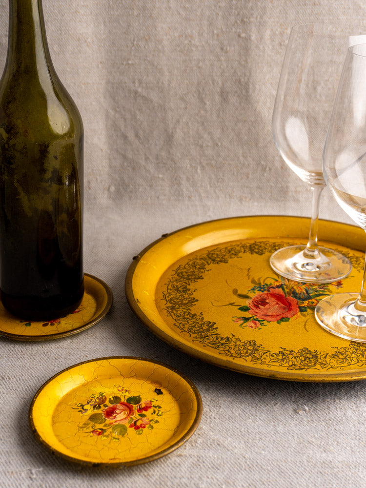 Antique French Tole tray set with yellow lacquered ground, late 19th century, styled with wine bottle, glasses, and floral plates.