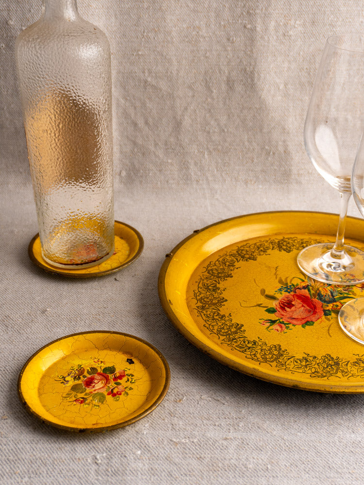 Antique French Tole Tray Set with yellow lacquer and floral designs, styled with glassware on beige fabric.