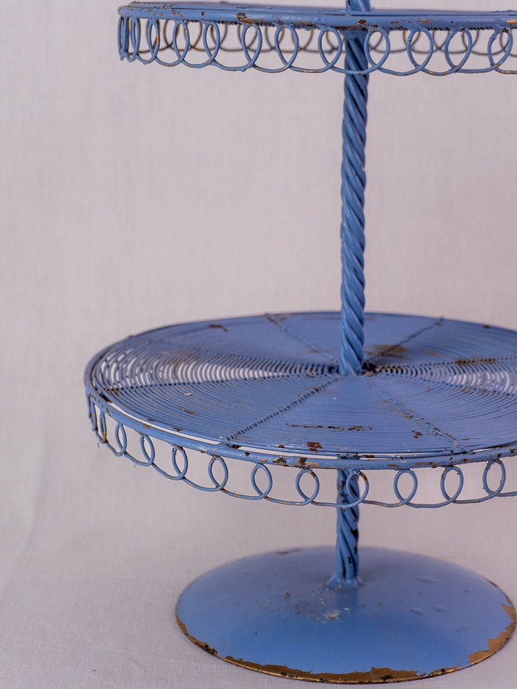 Antique French blue three-tier wirework pastry stand with spiral metal accents and distressed edges.