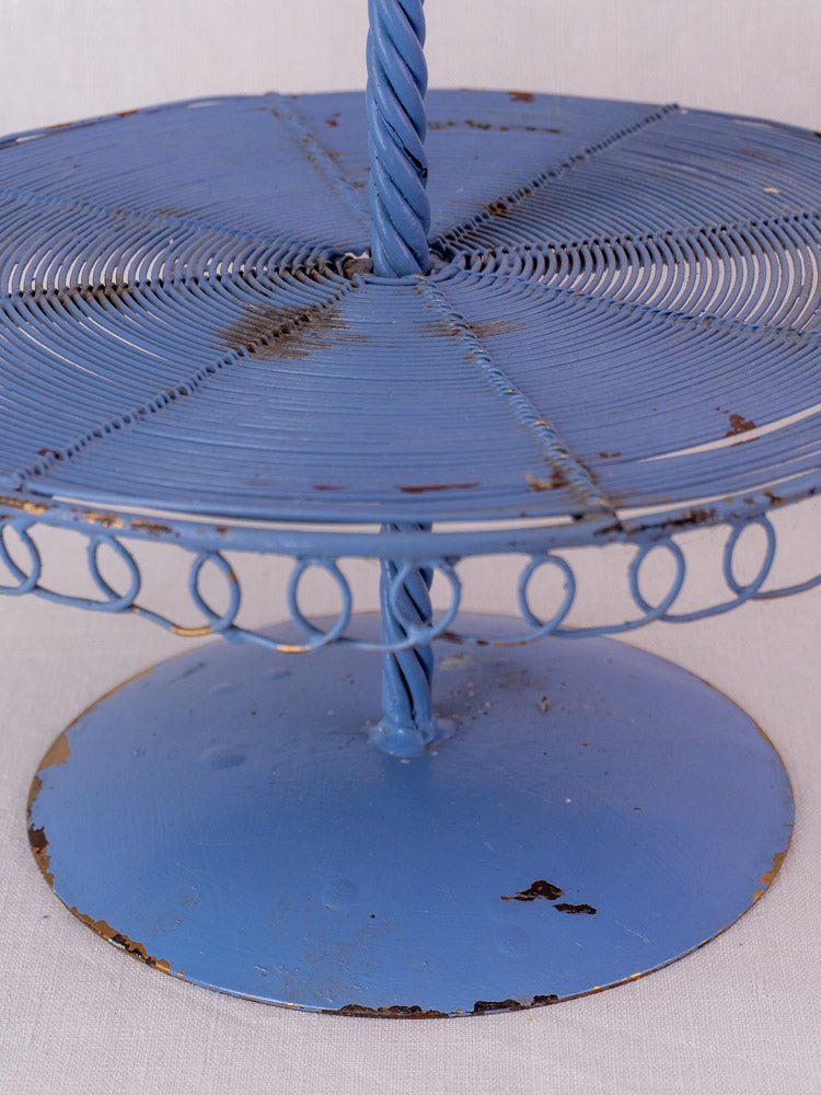 Antique French blue three-tier wirework pastry stand with vintage patina, rust, and decorative loops.