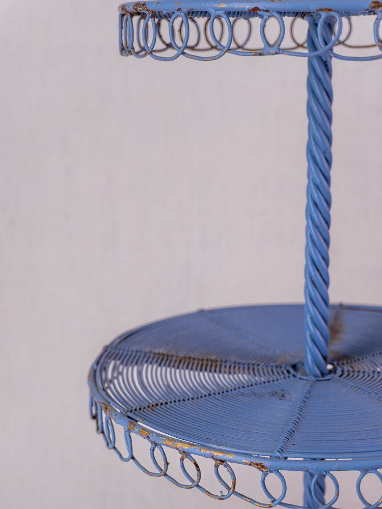 Antique French blue three-tier wirework pastry display stand with spiral support and circular edge details.