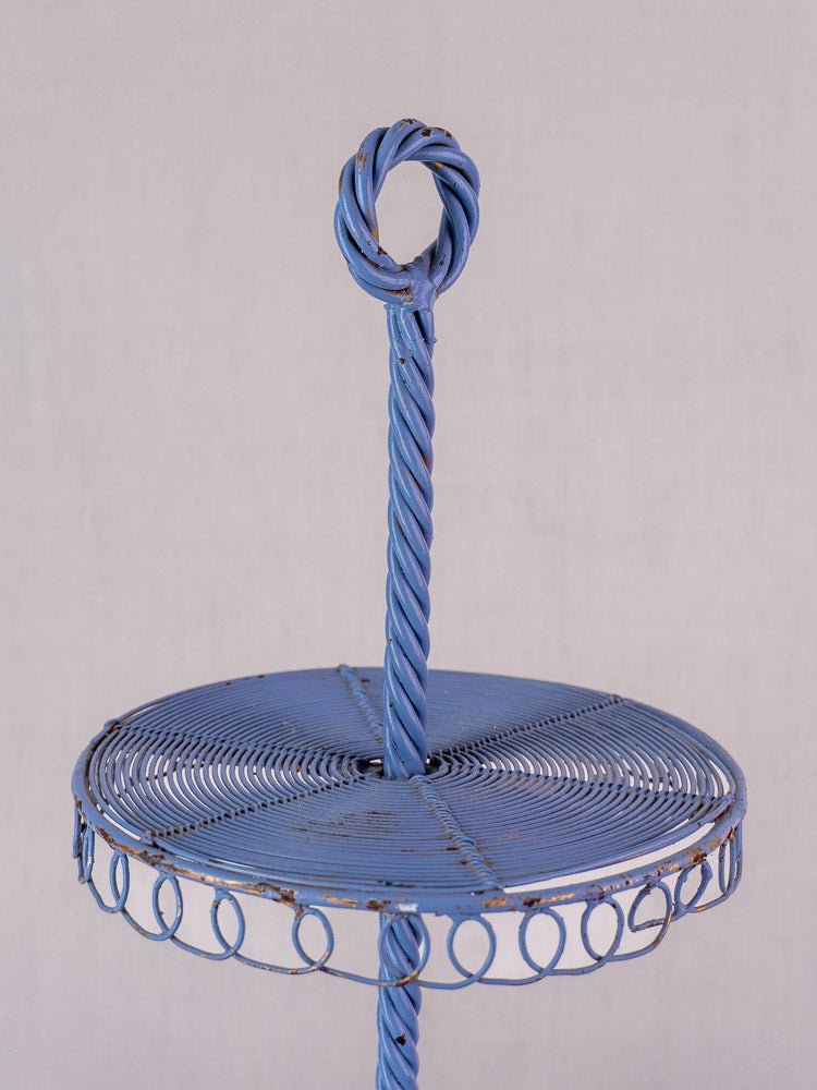 Antique French blue three-tier wirework pastry display stand with spiral and looped designs, plain background.
