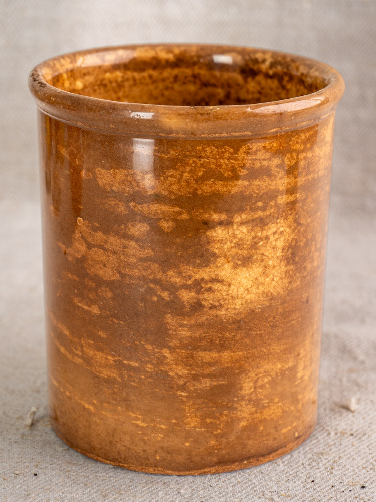 Antique French Creil et Montereau confiture pot with glossy brown glaze on light textured fabric.