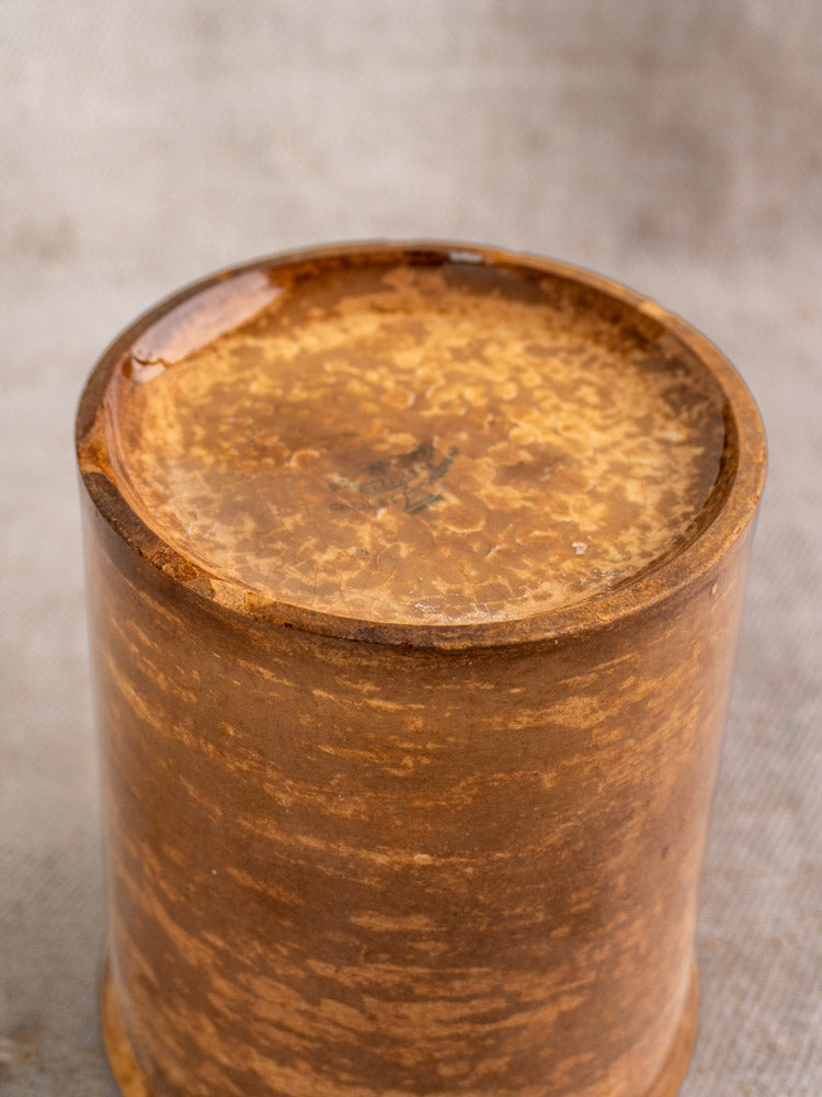 Antique French confiture pot by Creil et Montereau with brown glaze and lid on beige fabric.
