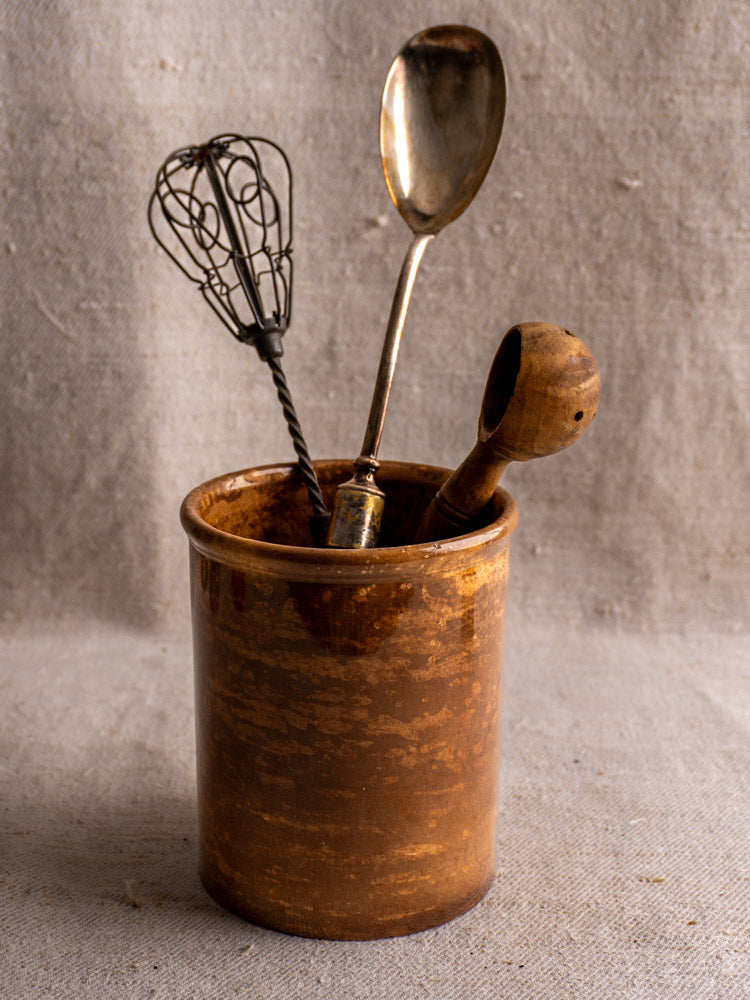 Antique French Creil et Montereau confit pot in brown glaze with whisk, silver spoon, and wooden scoop.
