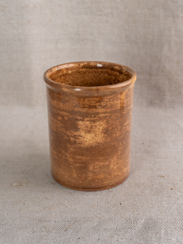Antique French confit pot by Creil et Montereau with brown glaze and mottled ceramic finish on beige fabric.