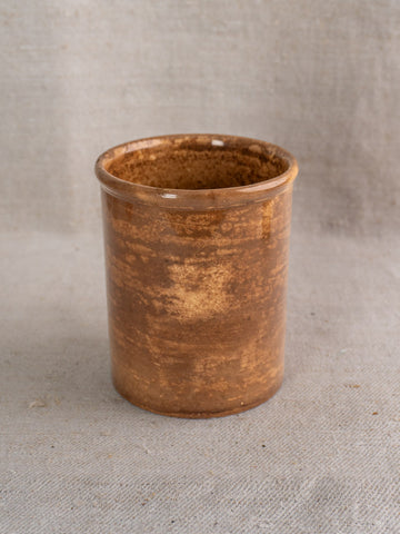 Antique French confit pot by Creil et Montereau with brown glaze and mottled ceramic finish on beige fabric.