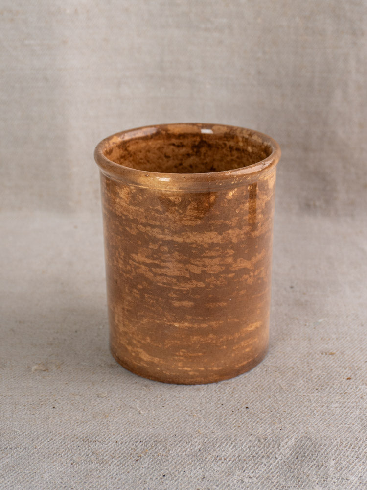 Antique French Creil et Montereau confit pot with brown glaze and flared rim on beige fabric.