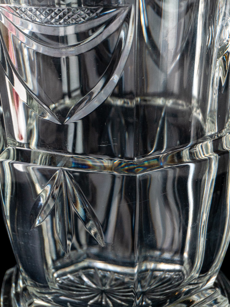 French cut crystal champagne bucket with intricate detailing, half-filled with water and elegant reflections.