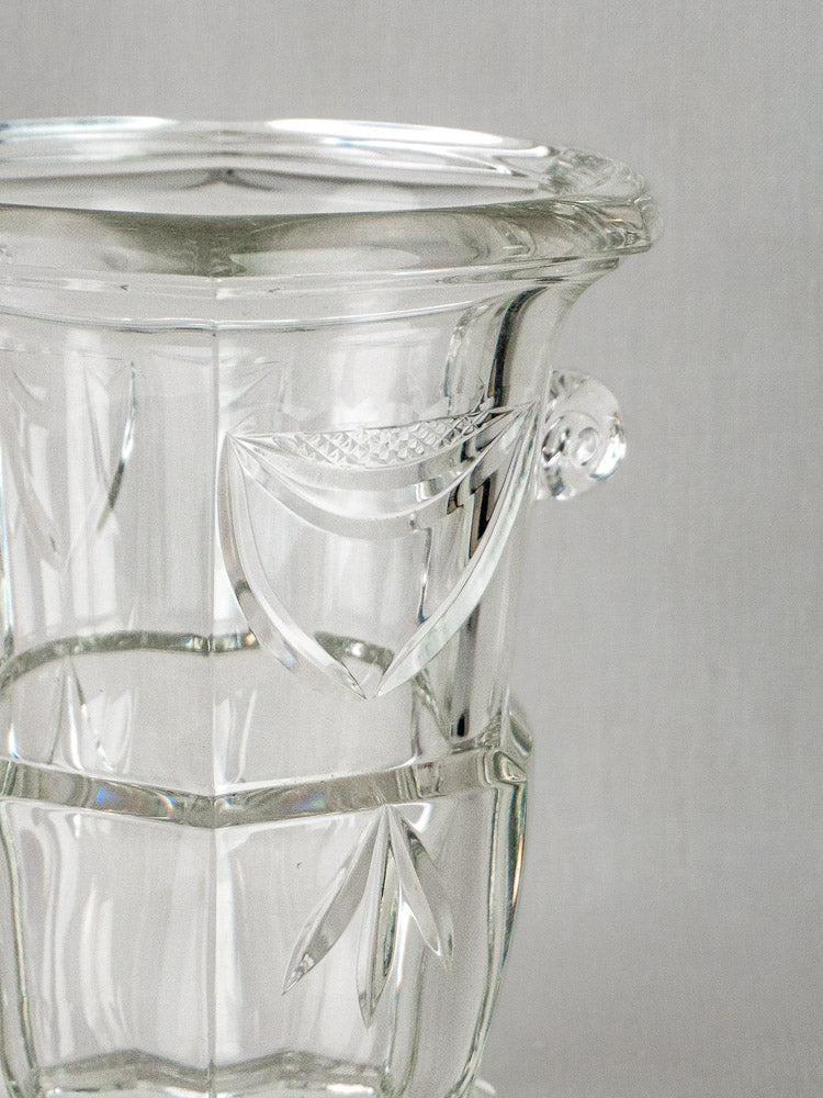 French vintage cut crystal Champagne bucket with etched leaf motifs and ornate side handle on gray background.