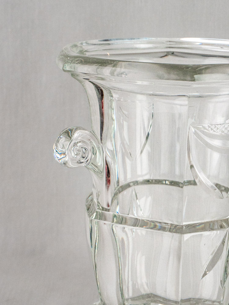 French cut crystal champagne bucket with geometric patterns and decorative handles, set against a light gray background.