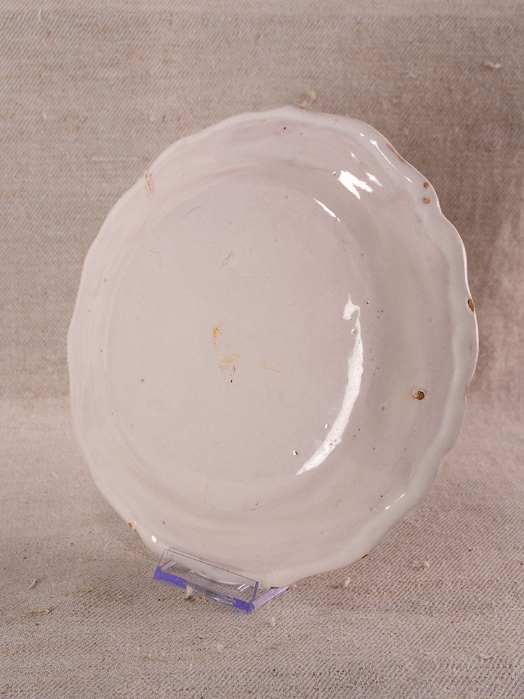 Pair of antique French faience plates with hand-painted turnip motifs, scalloped edges, and brown speckles.