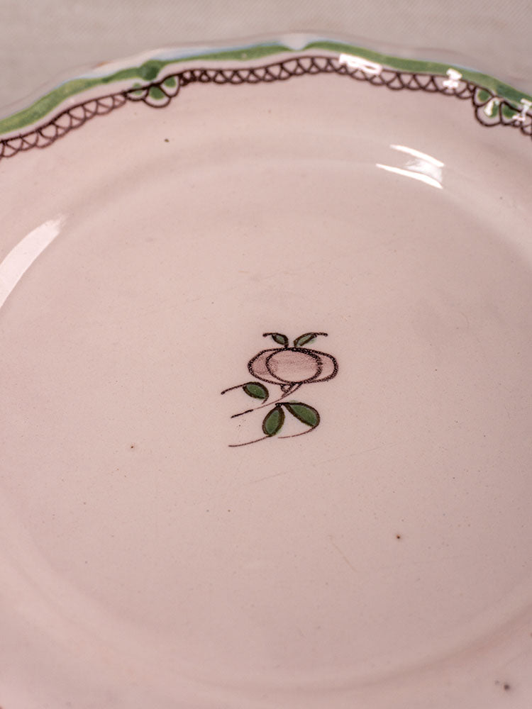 Antique French faience plates with hand-painted turnip motif and green-brown rim on off-white background.