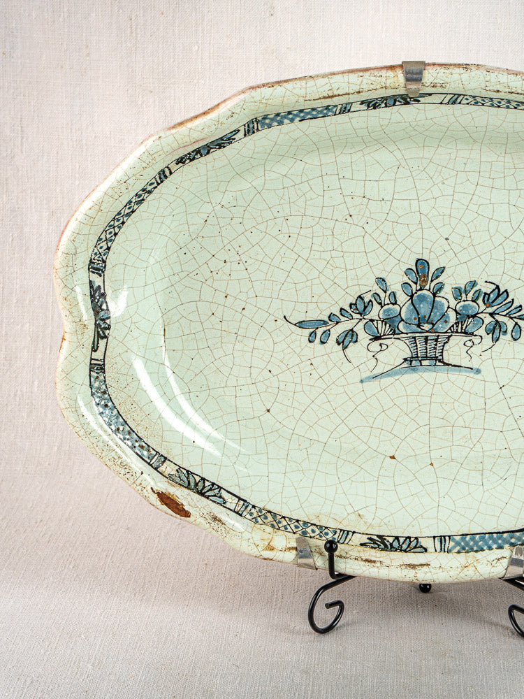 Pair of antique French Rouen-style faience platters with blue floral basket motifs on stands.