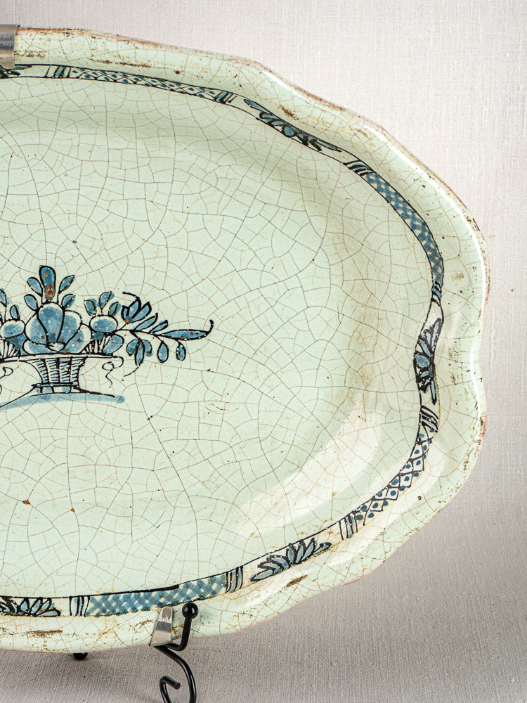 Antique French Rouen faience platters, oval ceramic with crackled glaze, blue floral motifs, scalloped edges.