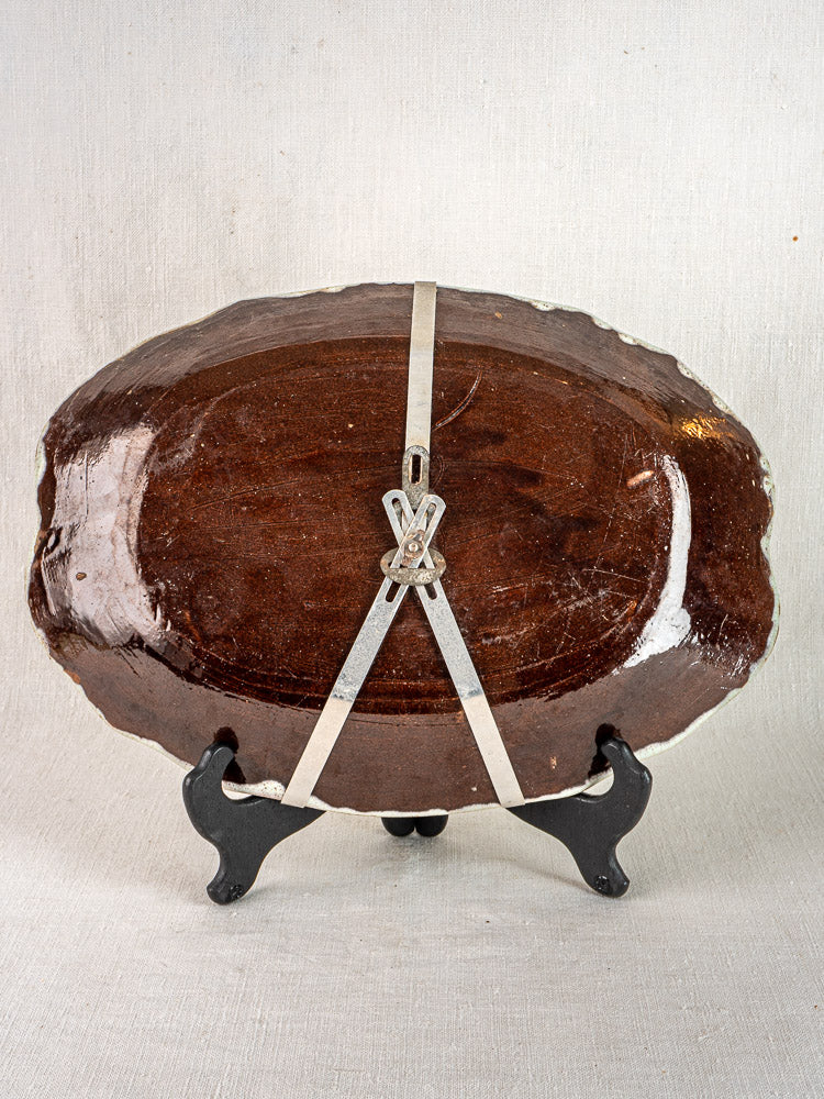 Pair of antique French Cul Noir faience platters, Rouen-style, on black stand with metal hanger.