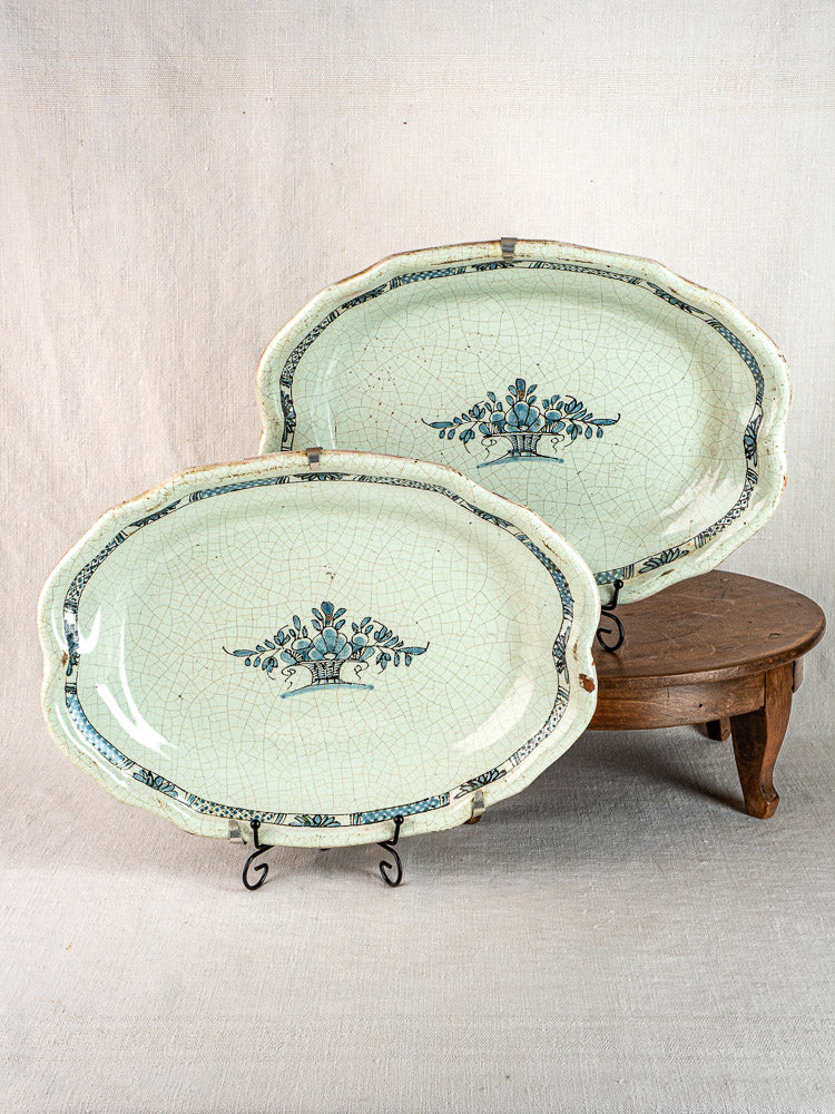 Pair of antique French faience oval platters, floral basket motif, dark blue borders, crackle glaze.