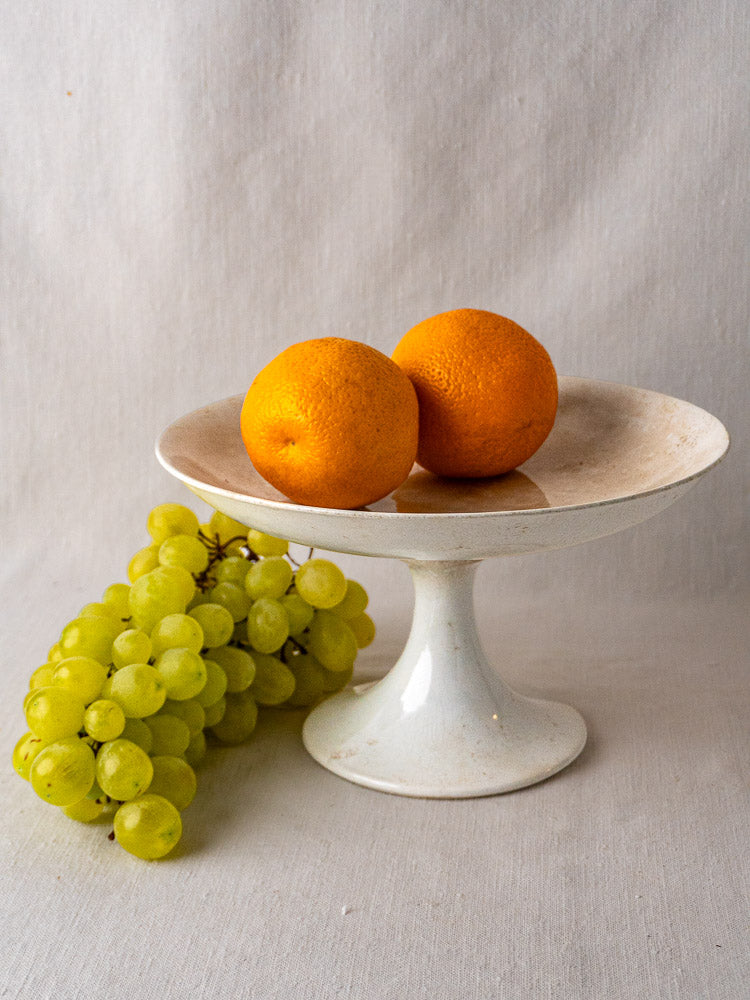 Antique French faience pedestal dish with wide shallow white craquelé ceramic bowl on narrow stem.