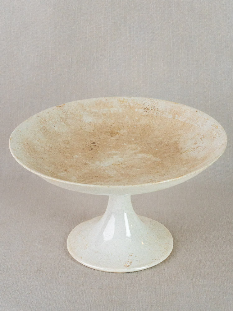 Antique French Longwy white craquelé faience compotier with wide shallow bowl on light gray background.
