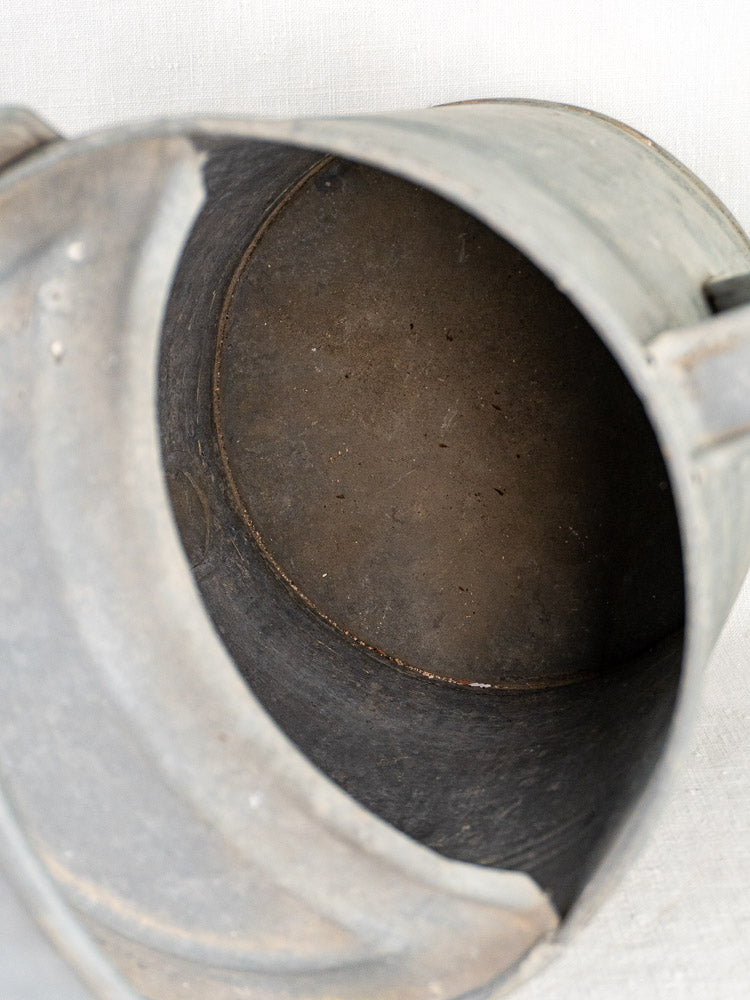Interior of French galvanized zinc long-spout watering can showing worn, rusted surface and vintage charm.