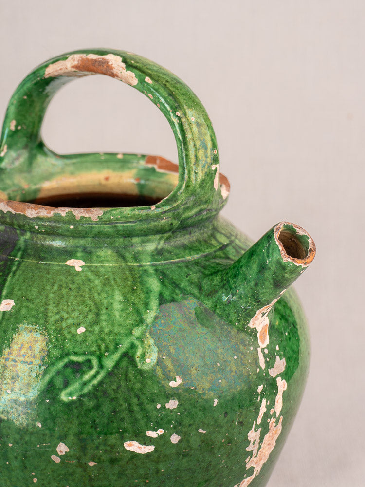 Antique French Provençal green-glazed gargoulette with rounded handle, short spout, and visible rustic earthenware chips.
