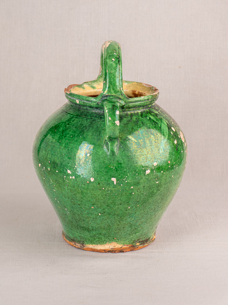 Antique French green-glazed Provençal gargoulette with single handle, wide body, and visible chips on earthenware.