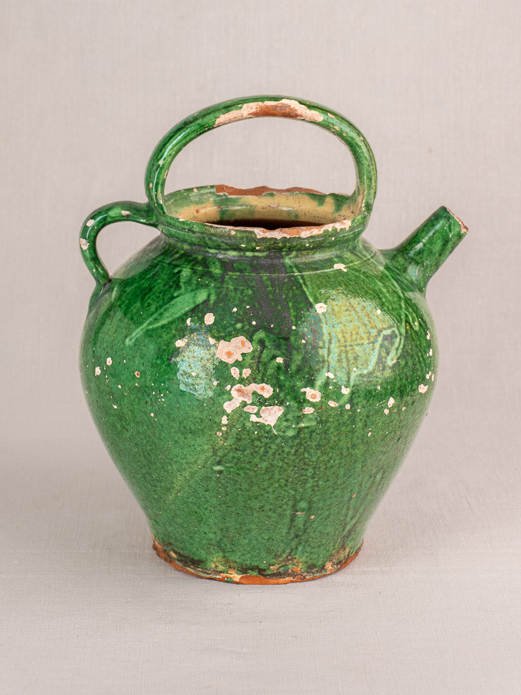 Antique French Provençal green-glazed earthenware gargoulette with rounded body, curved handle, side spout, and worn clay accents.