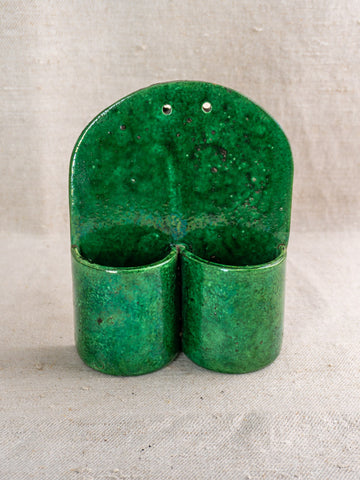 Antique French green earthenware wall utensil holder, late 19th–early 20th century, on neutral fabric background.