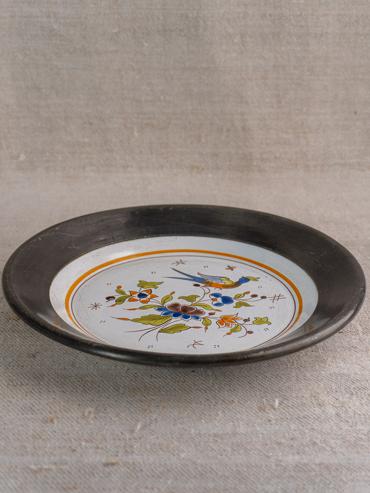 French faience wall plate, Moustiers style, pewter rim, bird and floral motif on beige fabric.