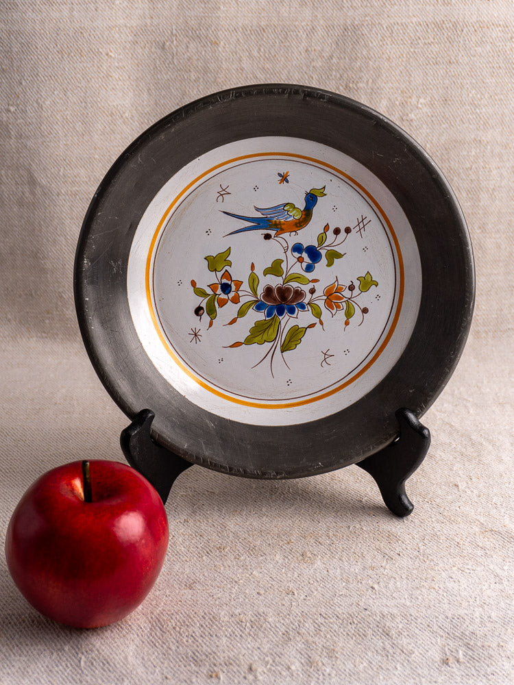 Hand painted French faience wall plate in Moustiers style with bird and floral motif on pewter stand.