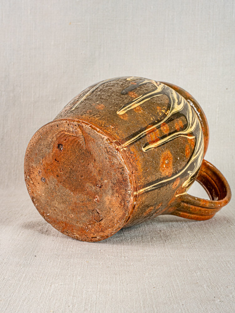 Antique French Savoie Pichet Jaspé slipware pottery with brown ceramic body, cream streaks, curved handle.