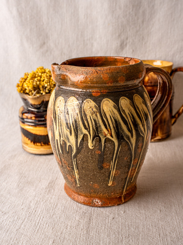 Antique French Savoie Pichet Jaspé with brown and tan marbled glaze on beige fabric.