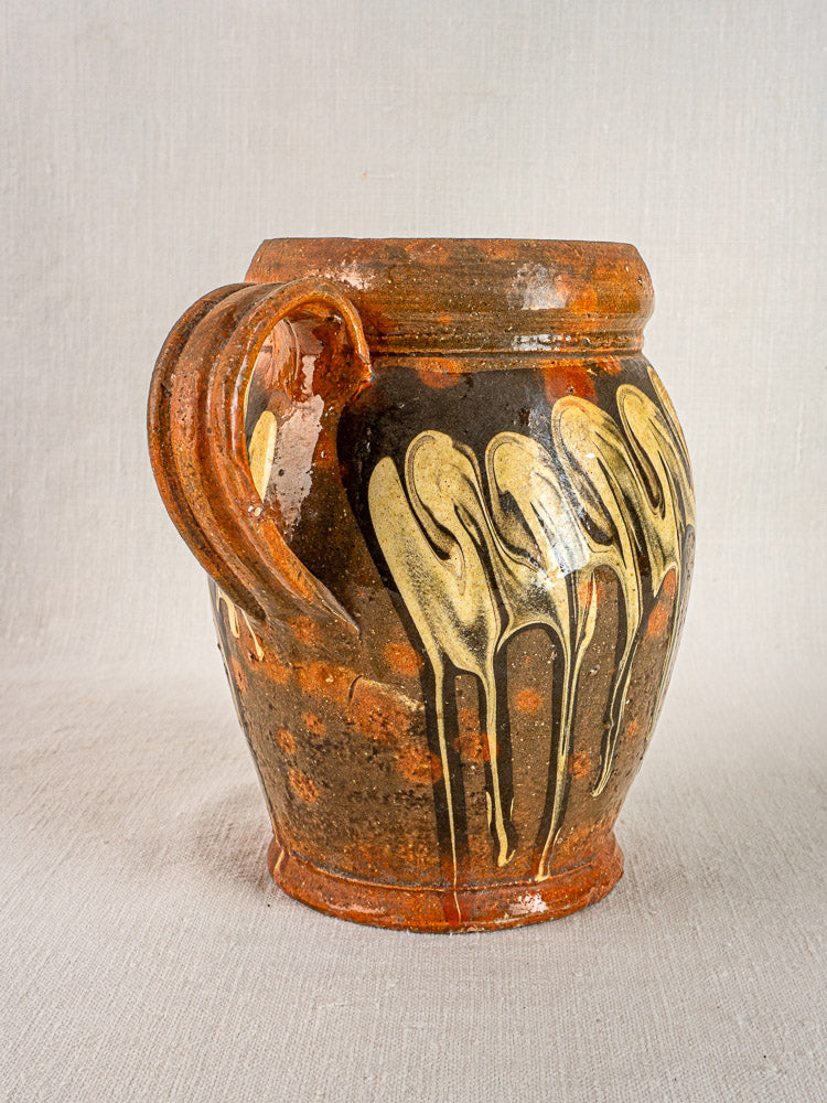 Antique French Pichet Jaspé, late 19th century brown slipware with cream and yellow dripped design on fabric.