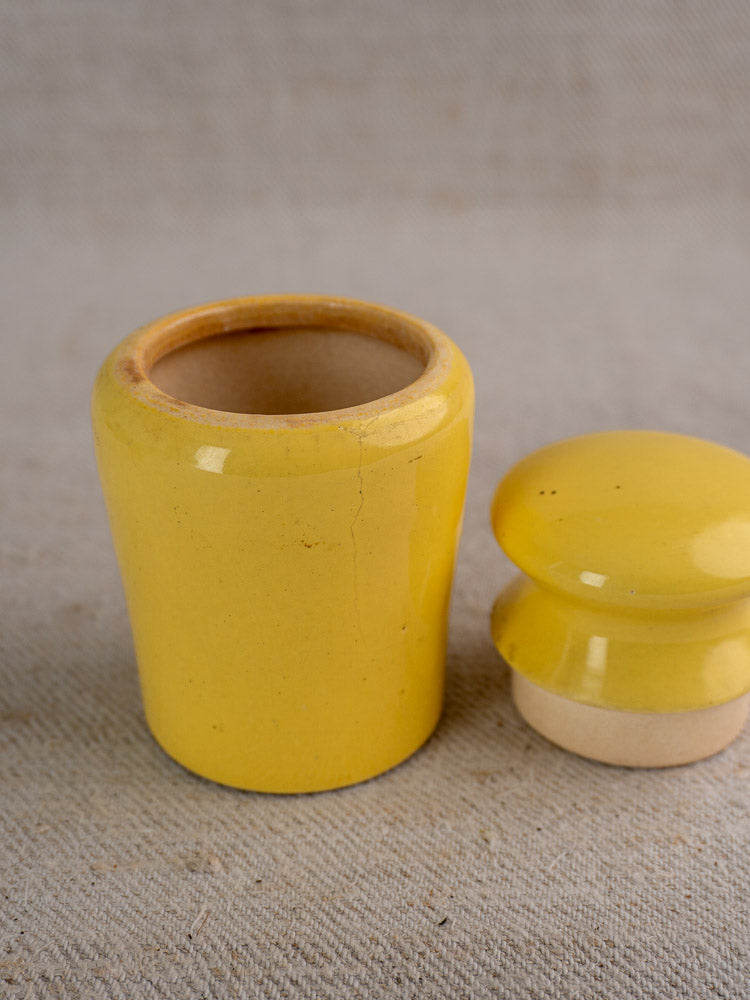 Pair of vintage French Maille mustard pots in yellow and teal with matching lids on neutral fabric.