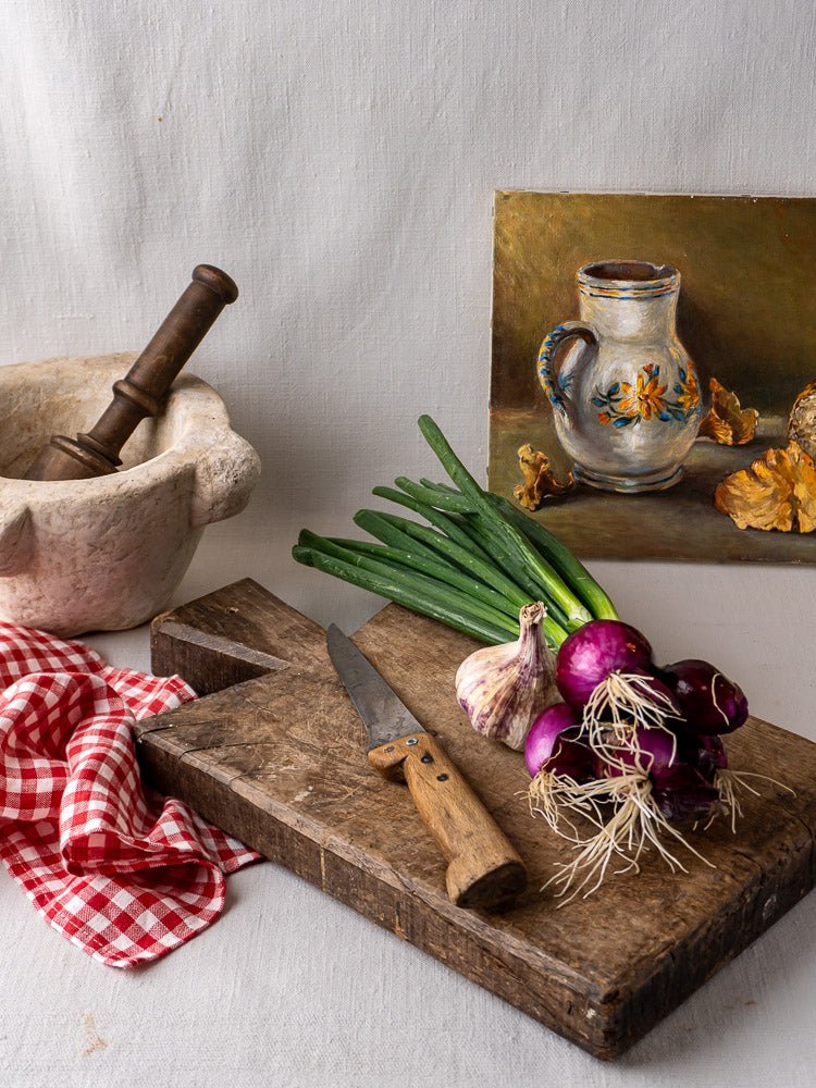 Antique 19th c. French hardwood cutting board with knife, mortar and pestle, vegetables, red checkered cloth.