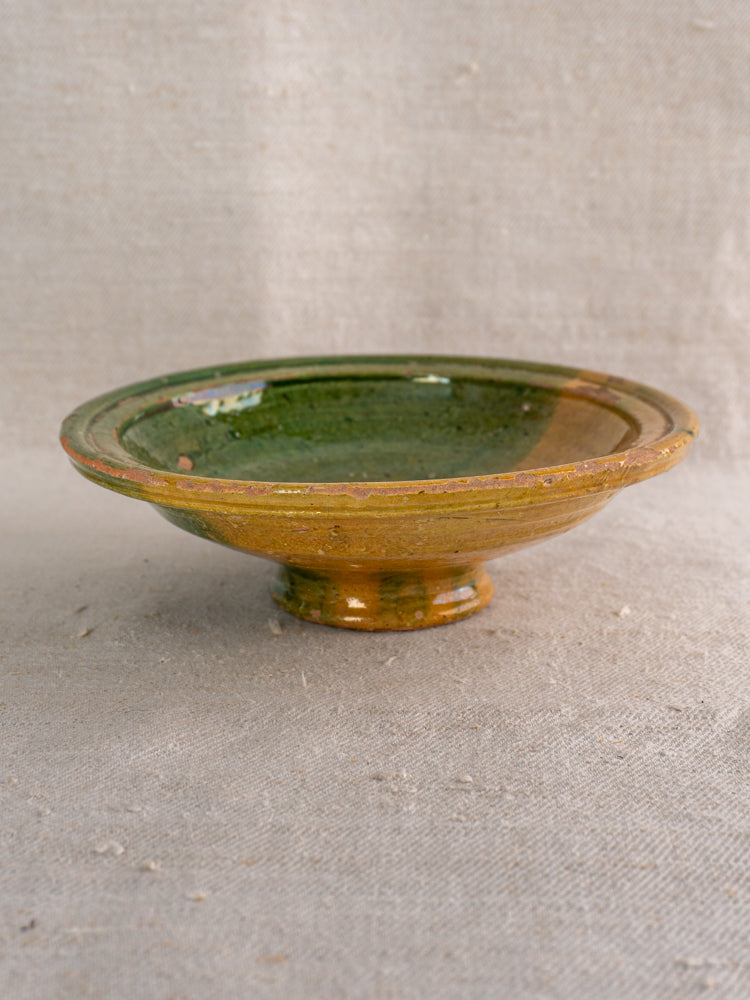 Late 19th century French Provençal compotier with pedestal base, green and ochre glaze on textured fabric background.
