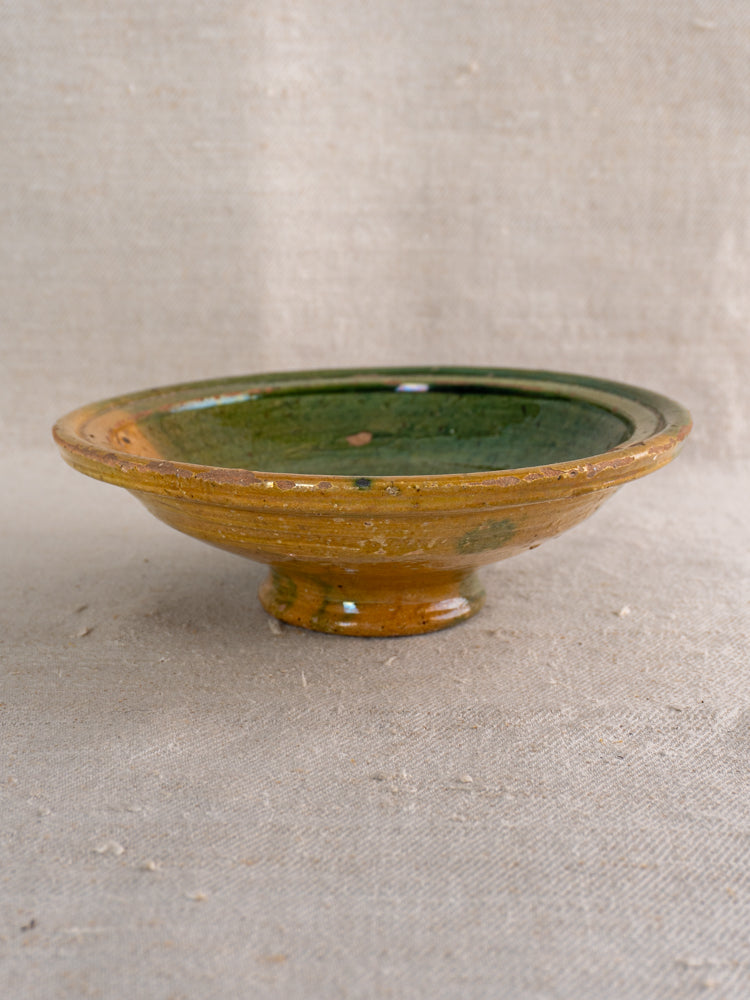 Antique French Provençal compotier with green and ochre glaze on beige textured fabric, late 19th-century earthenware.
