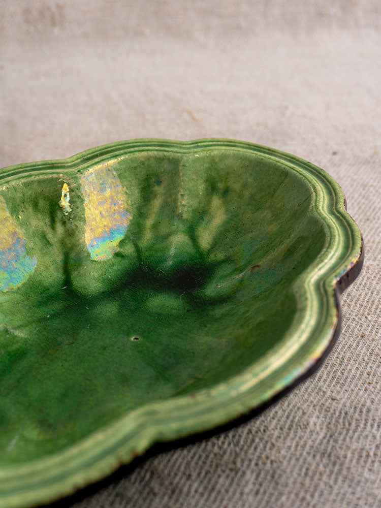 Antique French green glazed lobed oval coupelle with glossy finish, likely Dieulefit, on textured burlap.