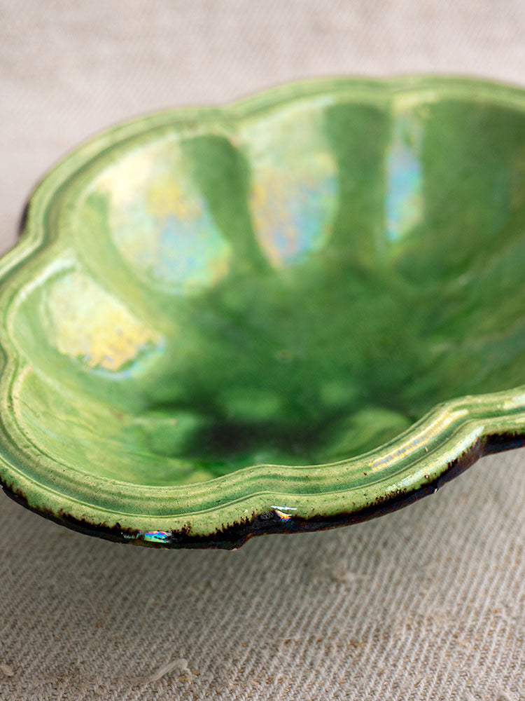 Antique French green glazed lobed oval coupelle, late 19th century, iridescent finish, on textured beige fabric.